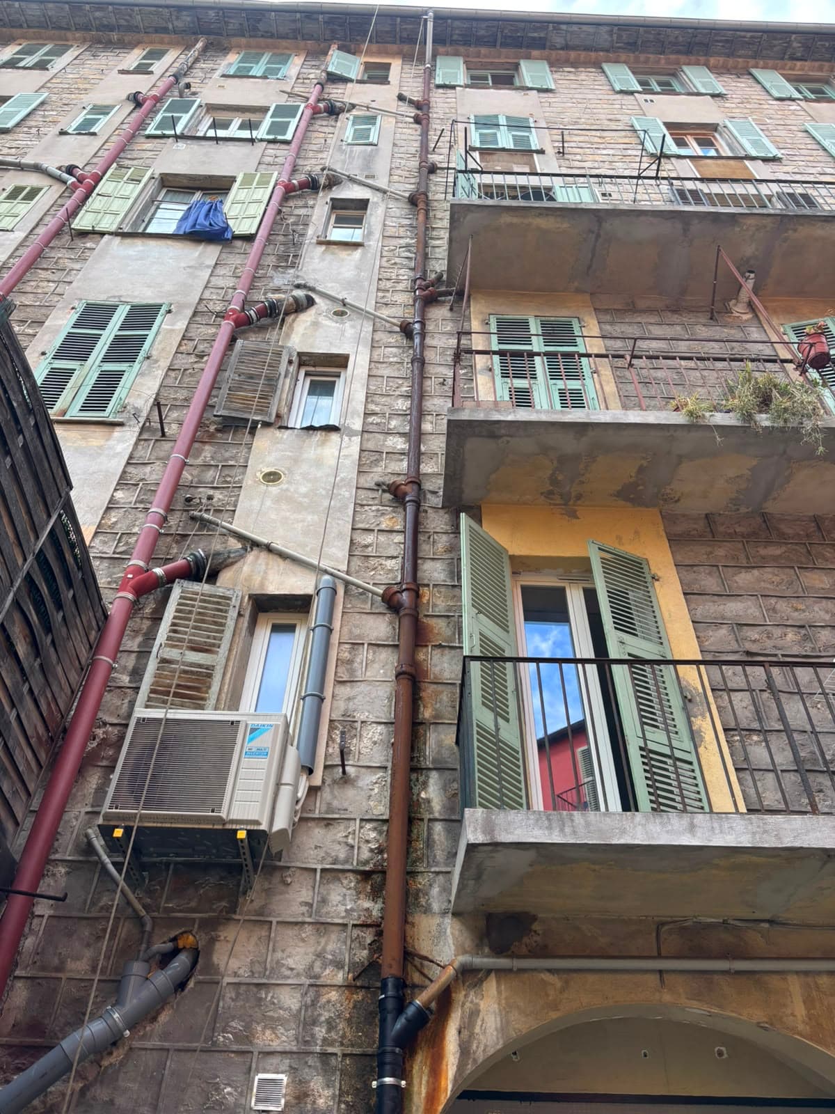 Colonnes de descente en fonte sur la façade d'un immeuble ancien du Vieux Nice